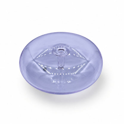 A translucent light purple circular plastic piece with an embossed eye design, resting on a white and gray marble surface.
