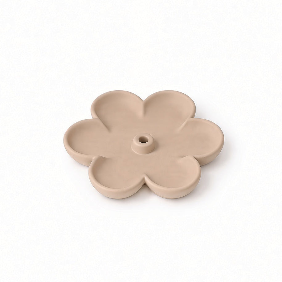 A small flower-shaped beige ceramic candle holder with a central hole, shown on a clean white background.