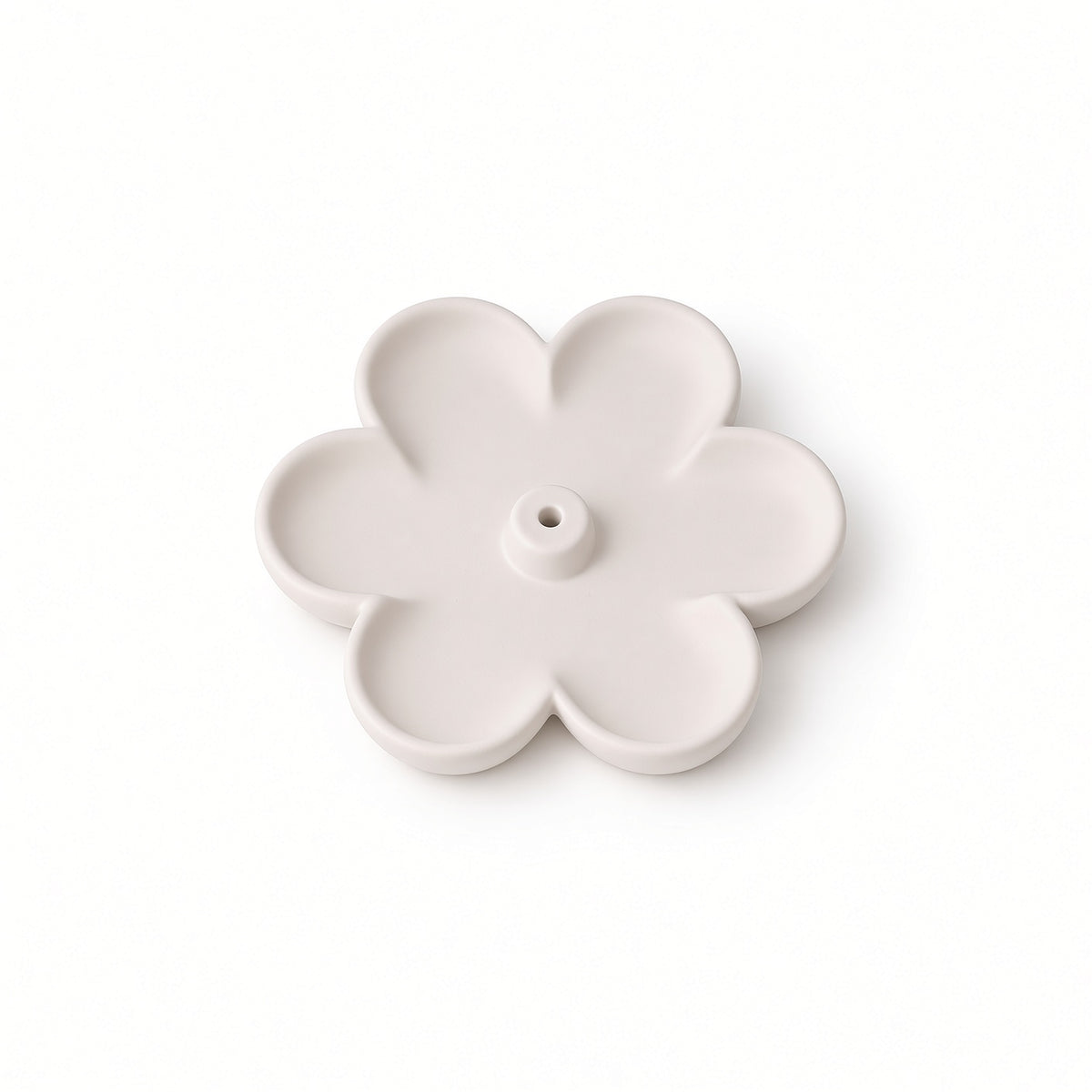 A single pale blush pink flower-shaped plastic component with five petals and a central hole, shown on a clean white background.