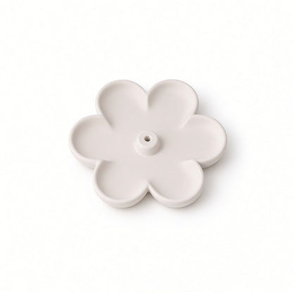 A single pale blush pink flower-shaped plastic component with five petals and a central hole, shown on a clean white background.